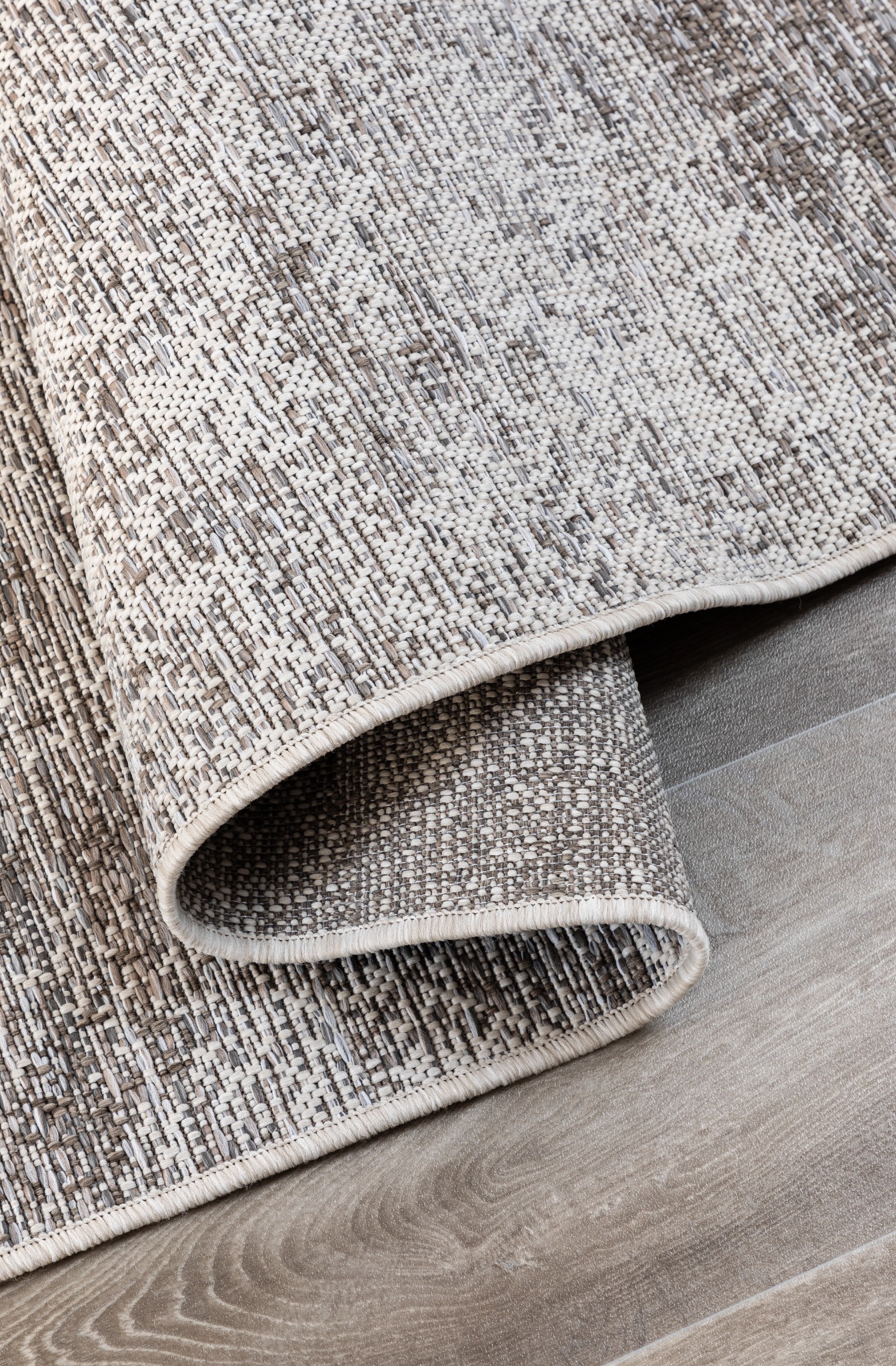 Dun grijs-beige vloerkleed, detail van de geweven structuur